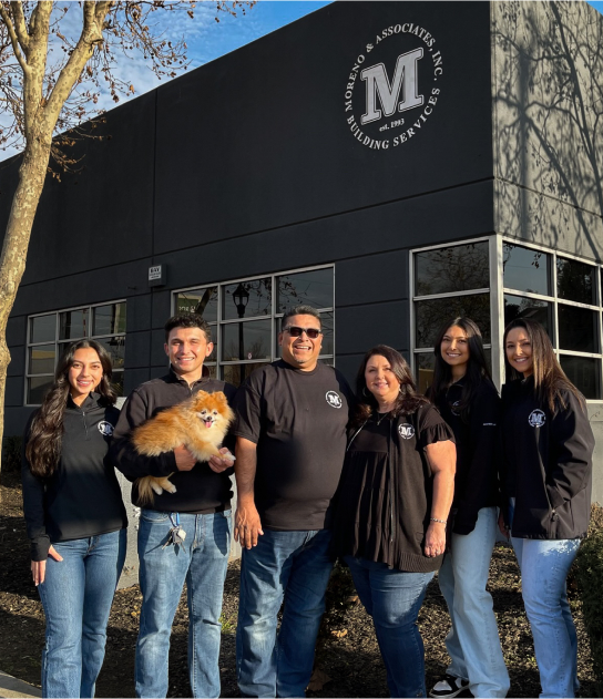 The Moreno family standing infront of the Moreno office building. From left to right, Kennedy, Kolbey holding their dog, bronco, then Ernesto, Stacie, Kassidy, and Kyleigh
