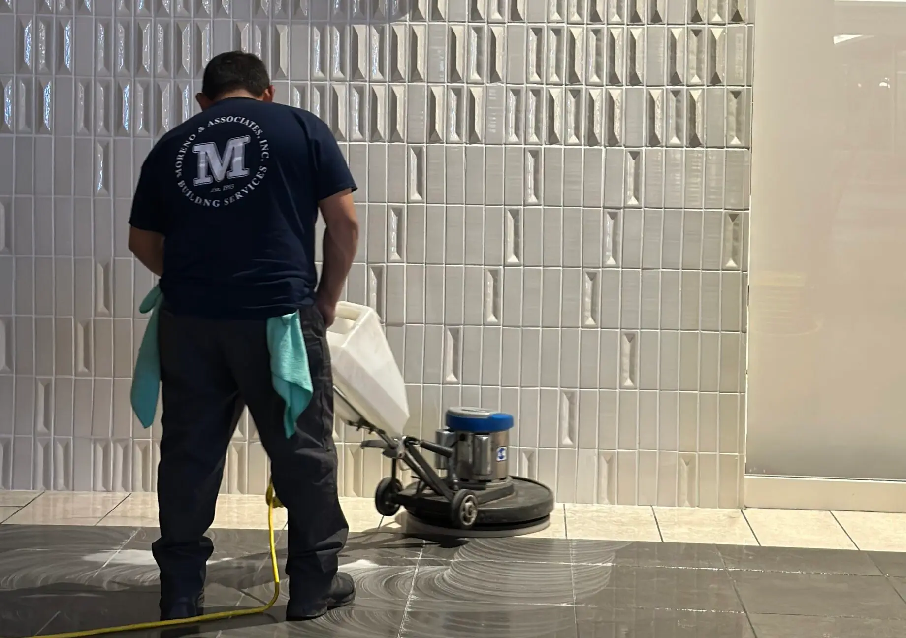 moreno employee using a floor machine to scrub tile floors