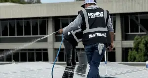 Commercial janitorial and maintenance team power washing solar panels